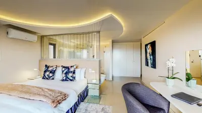 a bedroom with a bed and a desk and a chair at 7 on Marine in Hermanus