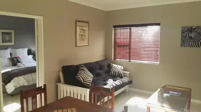 a living room with a couch and a bed at Bergsig Selfcatering in Gordonʼs Bay