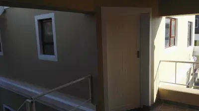 a room with a staircase and a window and a door at Bergsig Selfcatering in Gordonʼs Bay