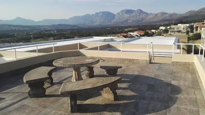 a table and benches on the roof of a building at Bergsig Selfcatering in Gordonʼs Bay