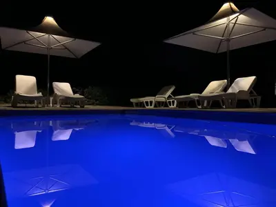 a group of chairs and umbrellas next to a swimming pool at Waterstone Lodge in Somerset West