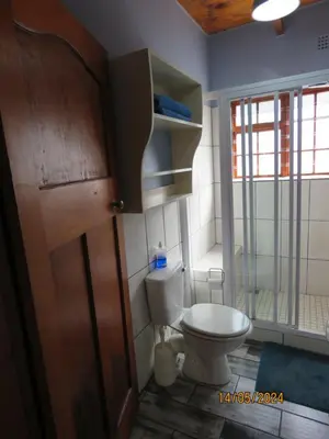 a bathroom with a toilet and a wooden door at Town and Country in Caledon