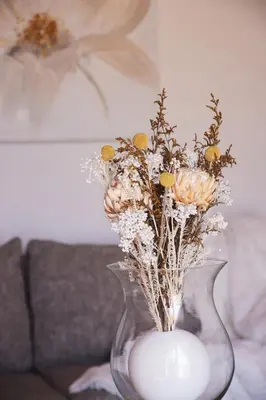 a clear vase with flowers in it on a table at Klein Waterval Riverside Lodge in Franschhoek