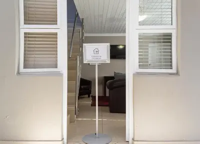 a sign in the middle of a room with windows at Ruslamere Hotel and Conference Centre in Durbanville