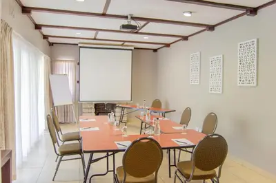 a conference room with tables and chairs and a whiteboard at Ruslamere Hotel and Conference Centre in Durbanville