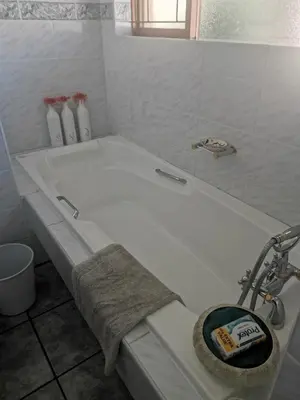 a bathroom with a bath tub with a faucet at Eikepark Self Catering in Stellenbosch
