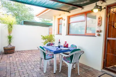a table and chairs sitting on a patio at Eikepark Self Catering in Stellenbosch