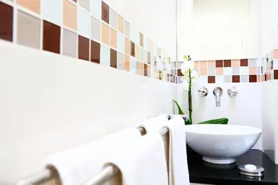 a bathroom with a white sink on a black counter at da Heim Guest House in Cape Town
