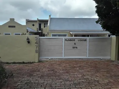 a white fence in front of a house at Fijnbos Manor in Bettyʼs Bay