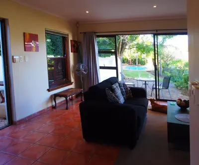 a living room with a couch and a view of a yard at Swallow's Nest in Somerset West