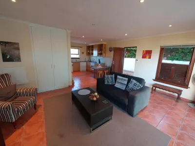 a living room with a couch and a table at Swallow's Nest in Somerset West