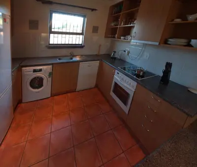 a kitchen with a washing machine and a washer at Swallow's Nest in Somerset West