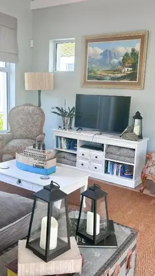a living room with a tv and a coffee table at Kallistes Misty Shores Cottage in Bettyʼs Bay