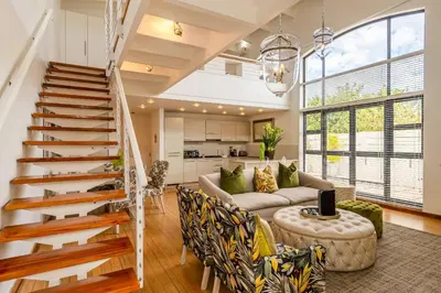 a living room with a staircase and a couch at The Ivy Apartments Franschhoek in Franschhoek