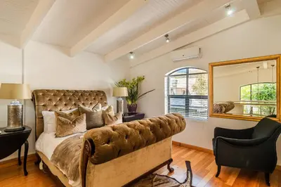 a bedroom with a large bed with a couch at The Ivy Apartments Franschhoek in Franschhoek