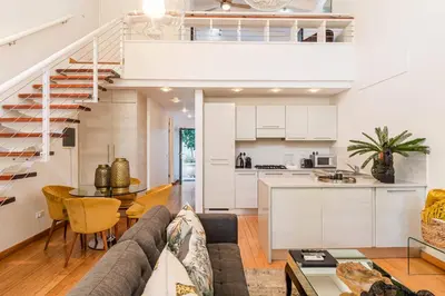 a living room with a couch and a table and a kitchen at The Ivy Apartments Franschhoek in Franschhoek