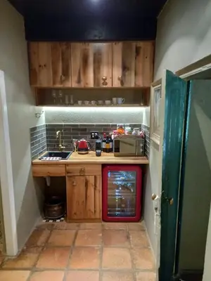 a small kitchen with wooden cabinets and a stove at Muratie Wine Estate in Stellenbosch