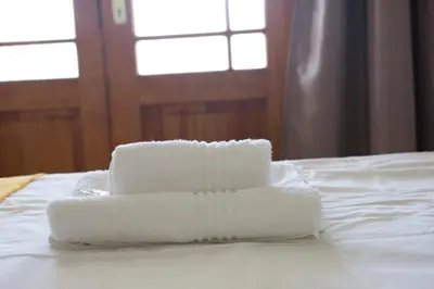 a stack of towels sitting on top of a bed at Windfall Wine Farm in Robertson