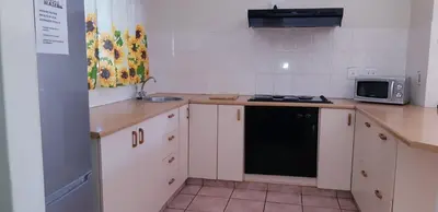 a kitchen with a stove and a microwave at Getaway Self-Catering Tyger Valley in Durbanville