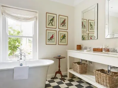 a bathroom with a tub and a window at La Cotte House in Franschhoek