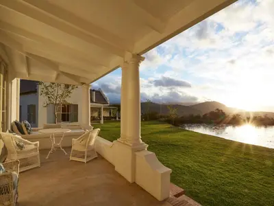 an outdoor patio with a view of a lake at La Cotte House in Franschhoek