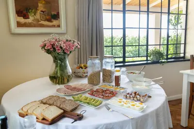 a table with a white table cloth with food on it at Elgin Country Lodge in Elgin