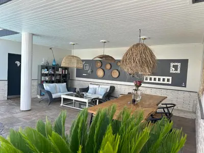 a living room with a wooden table and chairs at Southern Cross Guesthouse in Somerset West