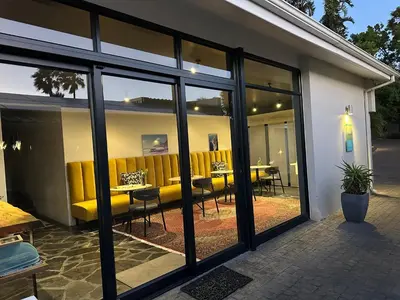 a room with windows and a table and chairs at Southern Cross Guesthouse in Somerset West