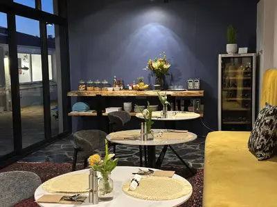 a room with two tables and chairs with flowers on them at Southern Cross Guesthouse in Somerset West
