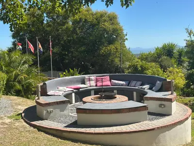a patio with a couch and a fire pit at Southern Cross Guesthouse in Somerset West