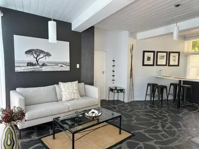 a living room with a white couch and a table at Southern Cross Guesthouse in Somerset West