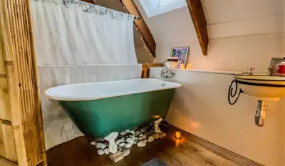 a bathroom with a green tub and a sink at Festina Lente in Onrus in Hermanus