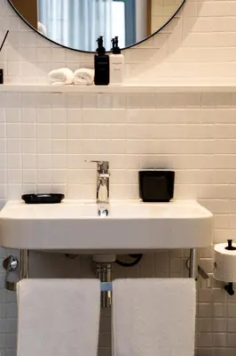 a bathroom with a sink and a mirror and towels at Eikehoff Apartments in Stellenbosch