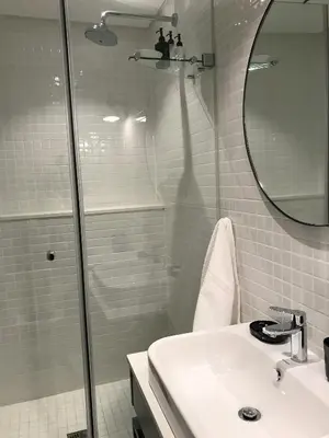 a bathroom with a shower and a sink and a mirror at Eikehoff Apartments in Stellenbosch
