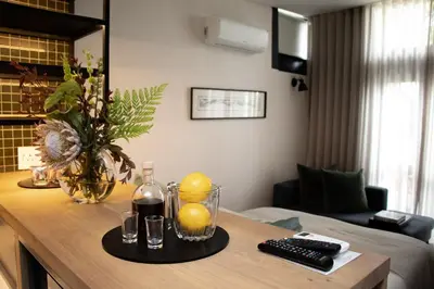 a room with a table with oranges and a bottle of wine at Eikehoff Apartments in Stellenbosch