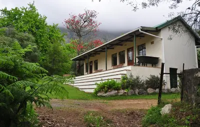 a white house with a fence in front of it at Kierie Kwaak Self Catering in Stellenbosch