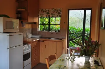 a kitchen with a table and a white refrigerator at Kierie Kwaak Self Catering in Stellenbosch