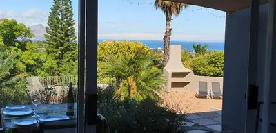 a room with a view of the ocean from a house at Agape Apartments in Somerset West