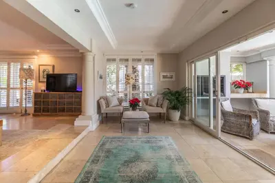 a living room with a couch and chairs and a tv at Maison du Cap in Cape Town