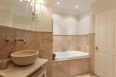 a bathroom with a bowl sink and a tub at Maison du Cap in Cape Town