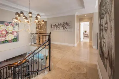 a hallway with a staircase with a chandelier at Maison du Cap in Cape Town