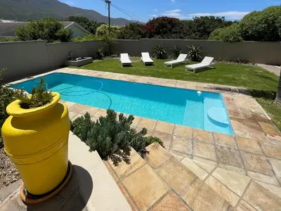 a small swimming pool with a yellow planter next to it at Bird's View Guest Accommodation in Hermanus
