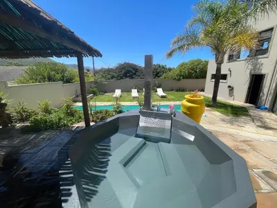a swimming pool with a sign next to a house at Bird's View Guest Accommodation in Hermanus
