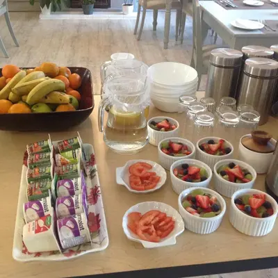 a table topped with bowls of fruit and vegetables at Howards End Manor B&B in Cape Town