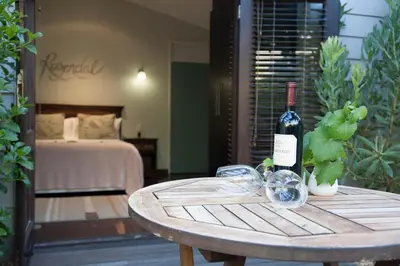 a bottle of wine sitting on a wooden table at Keren's Vine Guesthouse in Stellenbosch