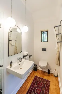 a bathroom with a white sink and a toilet at Hedge House Guest House in Cape Town