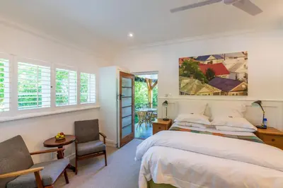 a bedroom with a bed and a table and chairs at Hedge House Guest House in Cape Town