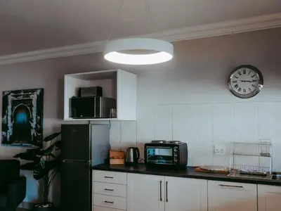 a kitchen with a refrigerator and a clock on the wall at Arcangeli Wines in Botrivier