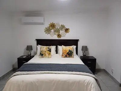 a bedroom with a large white bed with pillows at Arcangeli Wines in Botrivier