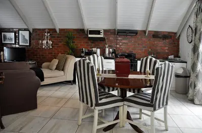 a living room with a table and chairs at Los Olivos at the Yard in Franschhoek